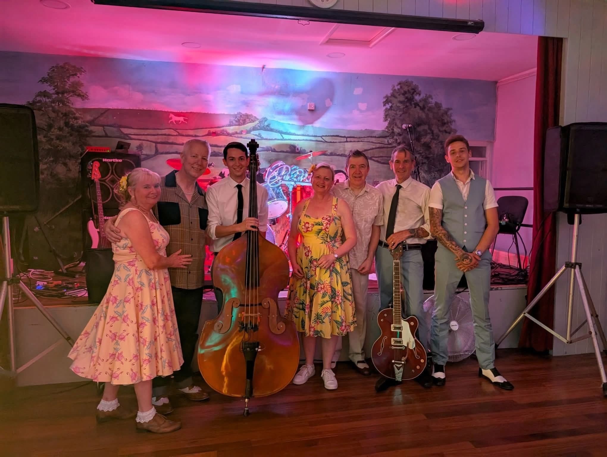 Band performing on stage with neon lights