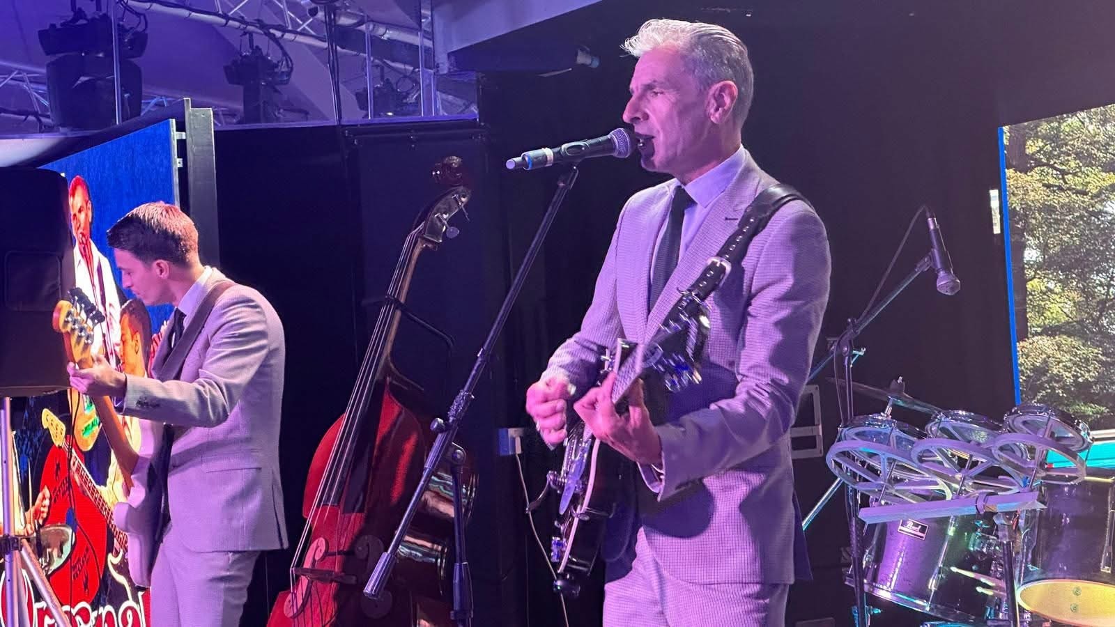 Guitarist and bassist on stage — outdoor festival