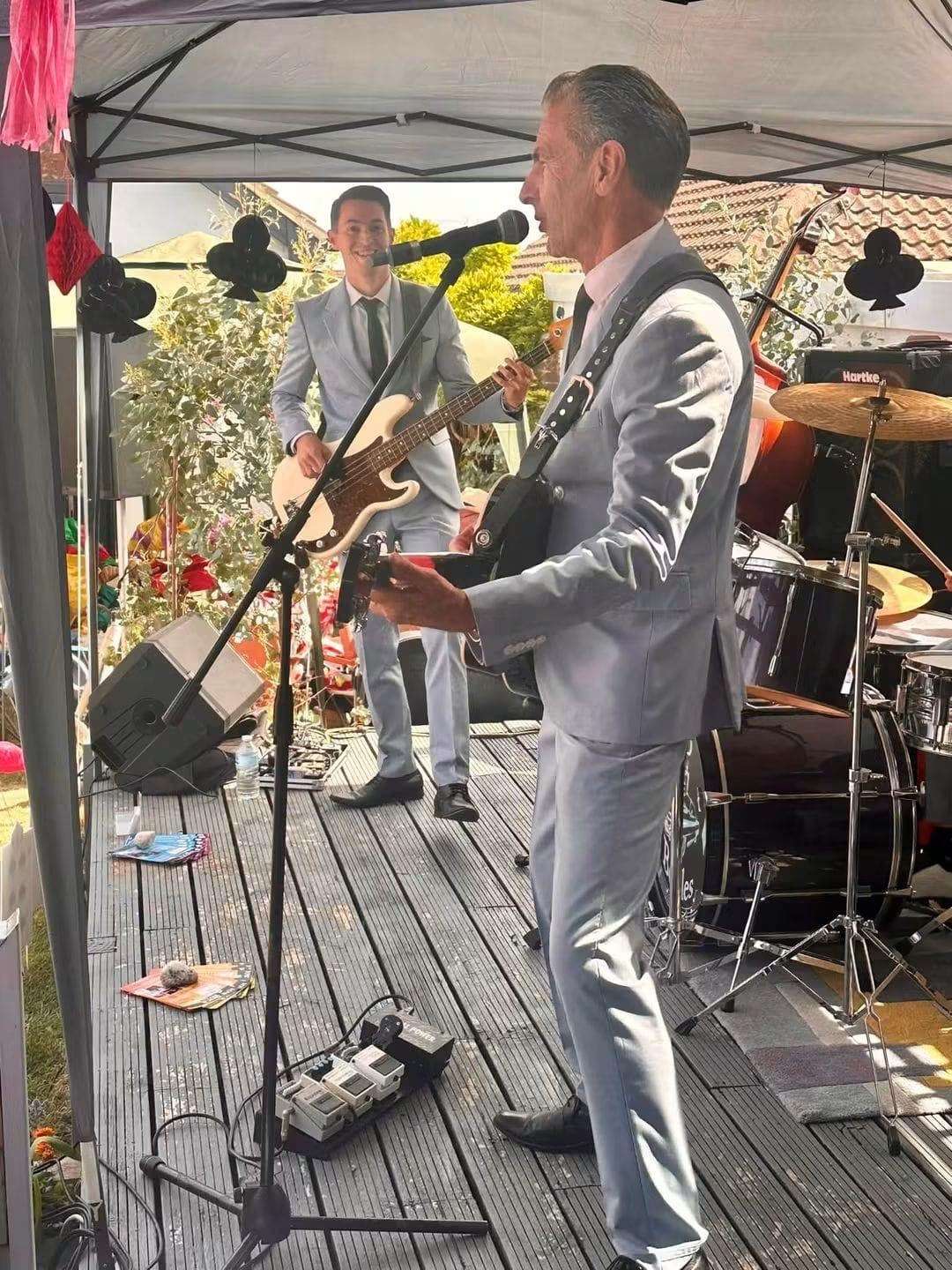 Guitarist and bassist performing at a garden party